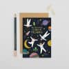 Vibrant space-themed birthday card featuring astronauts, planets, and rockets with the message "Hope your birthday is out of this world," perfect for science lovers and space enthusiasts.