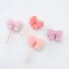 Pink bow-shaped marshmallow lollipops on white background, sweet treat, handmade confections, candy, dessert, colorful, gourmet sweets, bakery, snack, confectionery, The Wraperie.