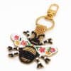 Brightly embroidered bee charm keychain with black, gold, white, pink, and green beads, attached to a gold keyring and clasp, perfect for jewelry or accessory customization.