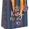 Colorful birthday gift bag with "King for a Day" message, crown illustration, orange ribbon handles, and multicolored confetti pattern, perfect for celebrating special occasions and birthdays.