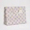 Deluxe gift bag with purple floral pattern, suitable for weddings, birthdays, and special occasions, featuring sturdy handles and elegant design from The Wraperie.