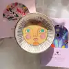 Sun face trinket dish with colorful design, ceramic with gold accents, perfect for jewelry storage or decorative use at The Wraperie.