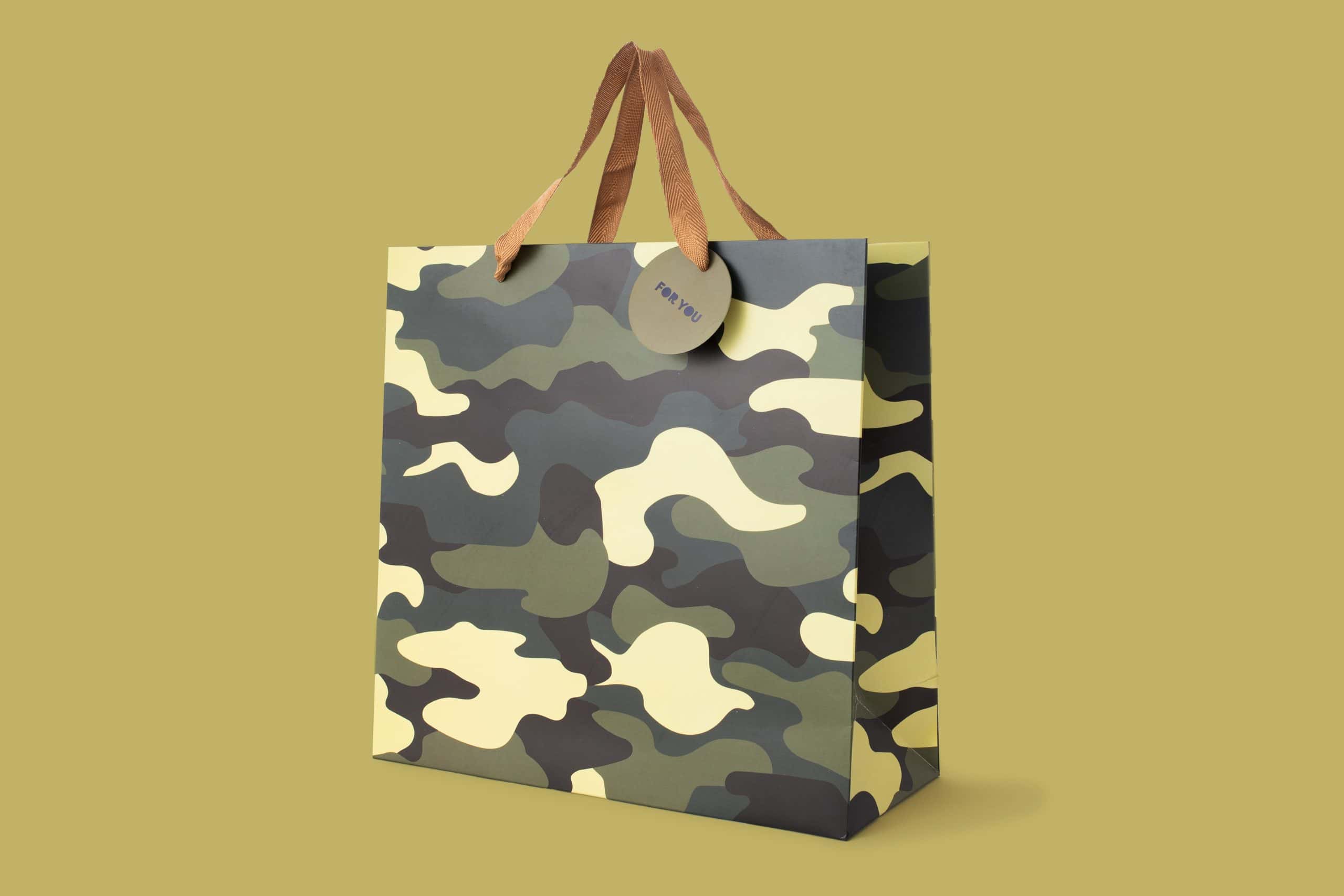 Camouflage patterned gift bag with kraft paper handles, perfect for custom gift presentation from The Wraperie.