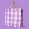 Lilac checkered gift bag with beige ribbon handles and pink heart tag, perfect for special occasions, from The Wraperie store.