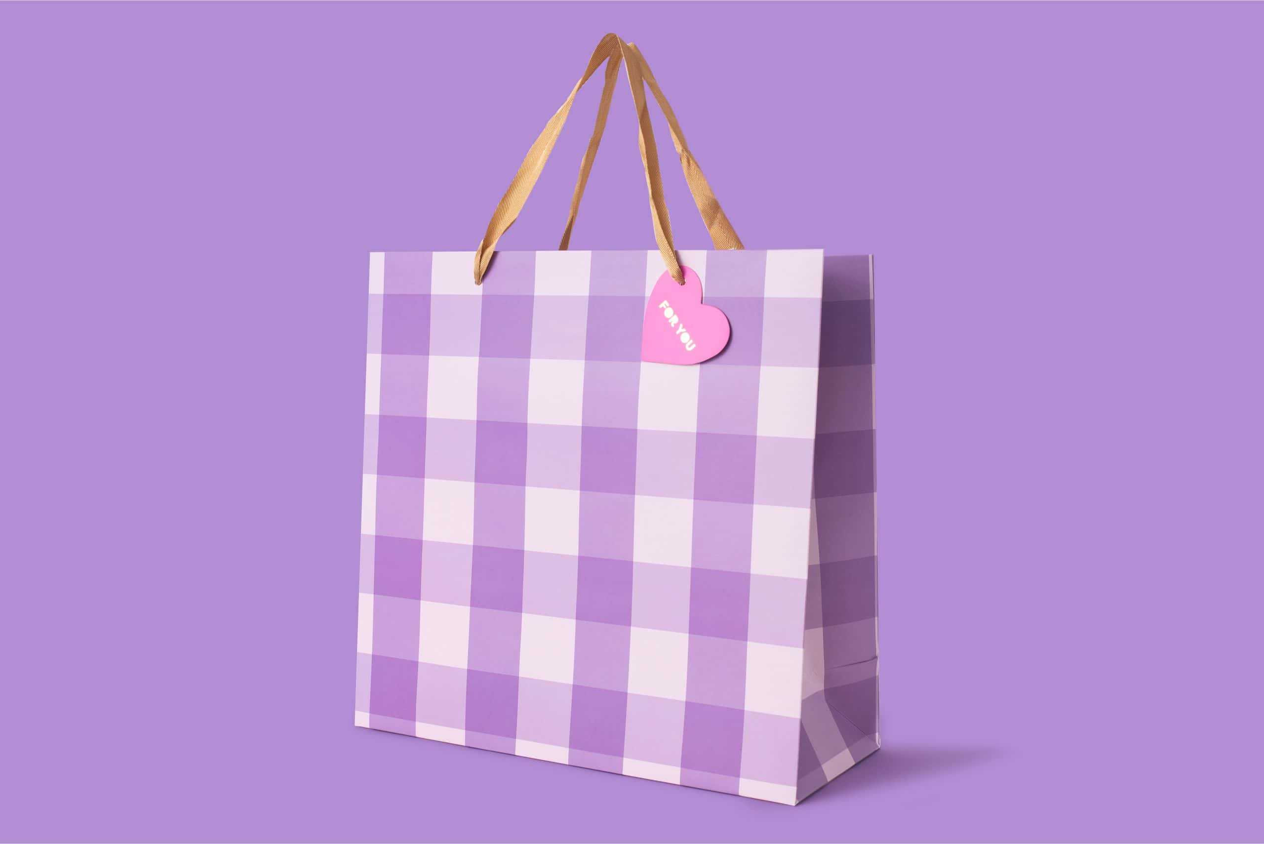Lilac checkered gift bag with beige ribbon handles and pink heart tag, perfect for special occasions, from The Wraperie store.