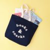 Colorful tote bag filled with children's books, perfect for storytime or gift-giving at The Wraperie.