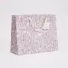Elegant purple floral gift bag with handles, perfect for gift wrapping or special occasions. Custom-designed by The Wraperie, adds a luxurious touch to any present.