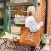 A woman with a tote bag that reads 