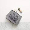 Travel toiletry bag with grooming essentials including a shaving brush and small toiletries, featuring motivational quote, ideal for men's grooming and travel accessories.