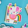 Colorful unicorn notebook with rainbow accents, hearts, and 
