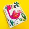 Bright colorful notebook cover featuring floral and flamingo illustrations with the text 