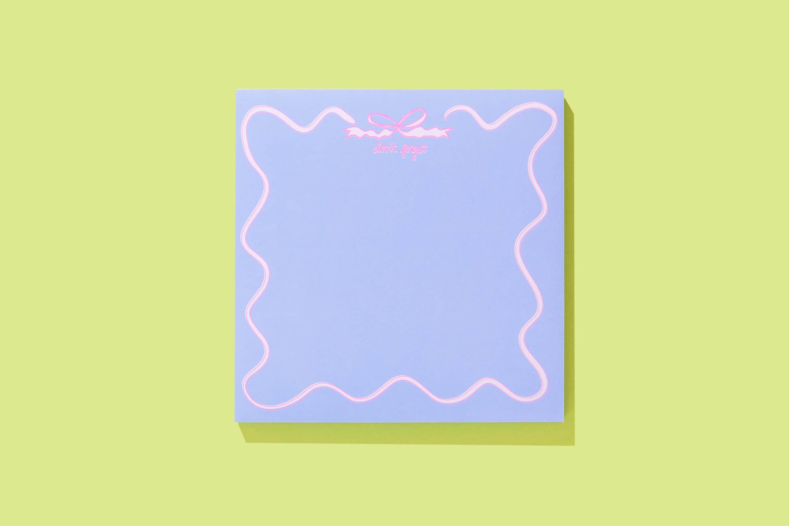 Neon pink "don't forget" message on pastel blue note card with pink border, modern stationery, and reminder theme.