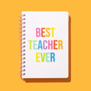 Bright spiral-bound notebook with colorful letters spelling "Best Teacher Ever" on a vibrant yellow background, celebrating teachers in a cheerful, engaging design.