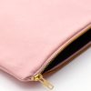 Soft pink zippered pouch made of durable fabric with gold zipper detail, perfect for organizing cosmetics, makeup, or accessories. Stylish storage option from The Wraperie.
