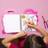 Colorful unicorn roller skate coloring book on a pink unicorn-themed table, child coloring with markers, fun and creative activity, perfect for kids' entertainment and art.