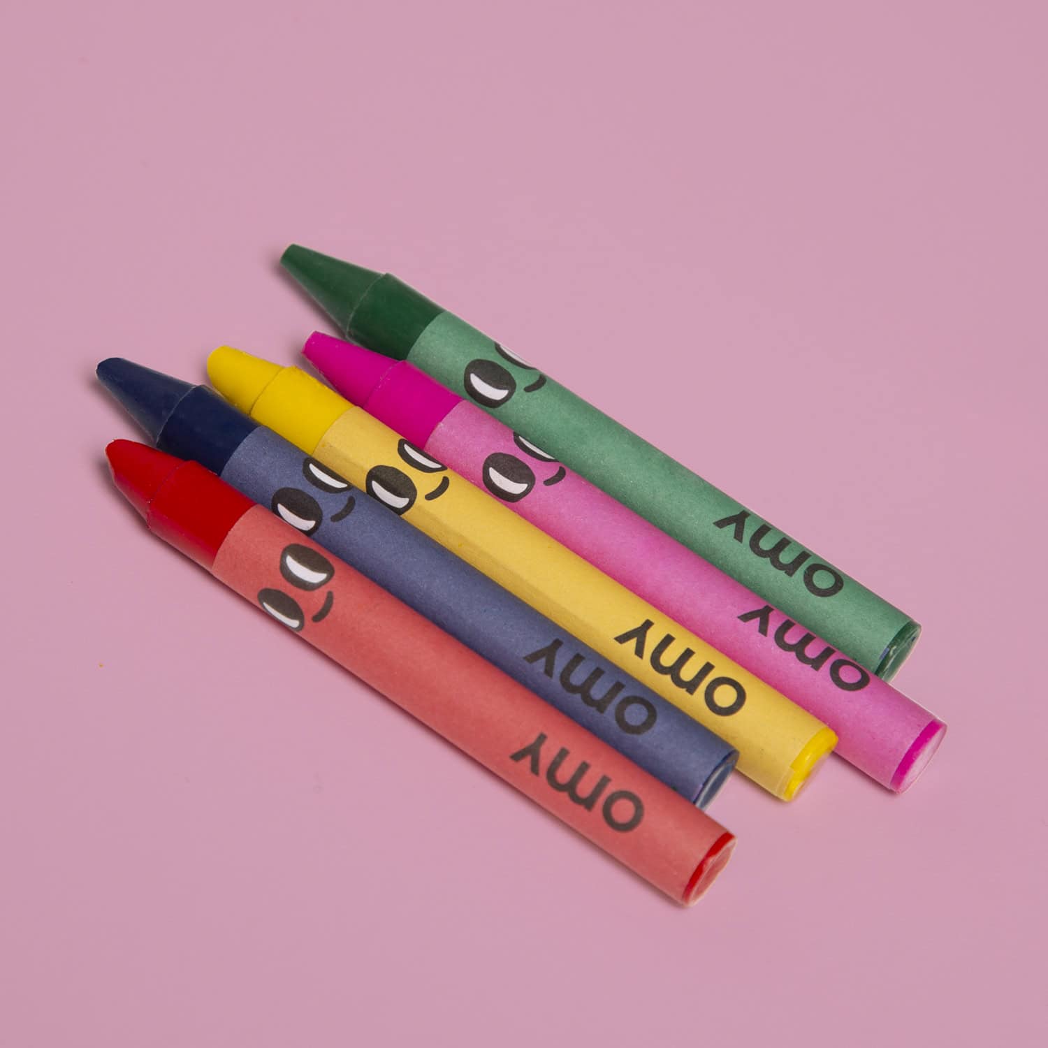 Crayons with cartoon faces in vibrant colors on pink background, fun creative art supplies for kids.