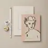 Minimalist stationery and art print from The Wraperie featuring a handwritten motivational message and a modern sketch of a woman. Perfect for inspiring daily positivity and stylish note-taking.