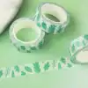 Green leaf patterned washi tape for decorative and craft projects, rolls of adhesive tape with nature-inspired design, perfect for wrapping, scrapbooking, and DIY creative endeavors.