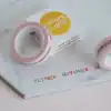 Colorful washi tape with months of the year printed in rainbow colors, displayed alongside a small box with the
