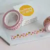 Nutmeg and arlo branded washi tape on marble surface with packaging from The Wraperie, featuring playful, colorful patterns and branding for cute, specialty tape for gift wrapping and crafts.