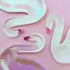 Colorful iridescent flamingo-shaped balloons on a pastel pink background, perfect for party decor or fun birthday celebrations.