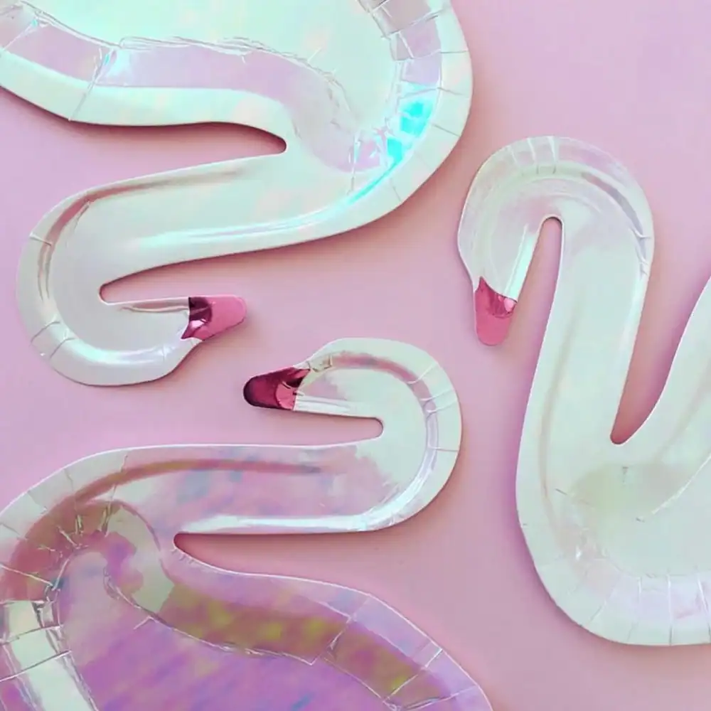 Colorful iridescent flamingo-shaped balloons on a pastel pink background, perfect for party decor or fun birthday celebrations.