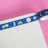 Colorful space-themed washi tape with stars, moons, and planets design for decorative stationery or crafting.