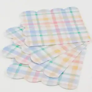 Colorful pastel plaid paper wrappers for baked goods and party favors, perfect for spring or Easter celebrations. Ideal for wrapping cupcakes, candies, or small treats with a charming, festive touch.