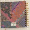 Vibrant floral patterned notebook with gold spiral binding, perfect for journaling, note-taking, and scrapbooking. Unique multicolor designs inspired by nature and bohemian aesthetics.